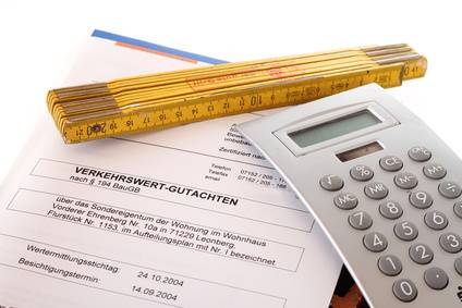 Zollstock, Taschenrechner und ein Gutachtendokument